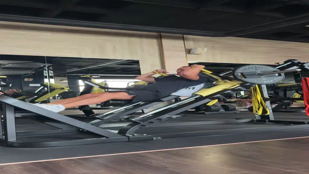 Cliente en prensa de piernas con un coach de BodyLine en la sala, Tenerife Sur